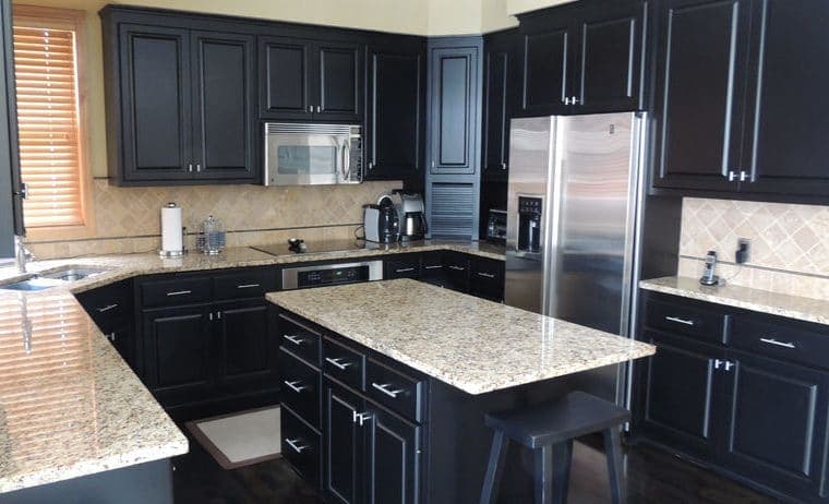 Kitchen cabinets refinished in navy lowers and soft white uppers with black pulls